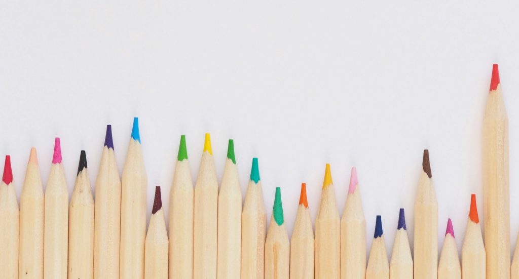 colored pencil lined up on top of white surface